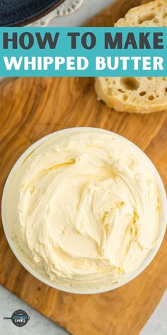 a white bowl filled with whipped butter sitting on top of a wooden cutting board next to bread