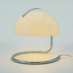 a white table lamp sitting on top of a metal stand next to a light bulb