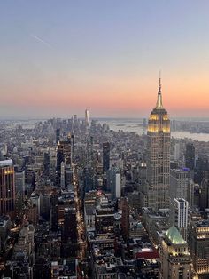 an aerial view of the empire building and surrounding skyscrapers in new york city at sunset