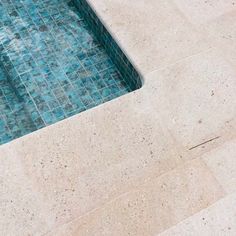 an empty swimming pool with blue tiles on the floor