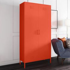 an orange cabinet in the corner of a living room next to a blue chair and lamp