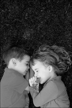 two young children laying on the ground next to each other