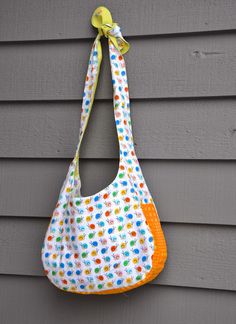 an orange and white purse hanging on the side of a house