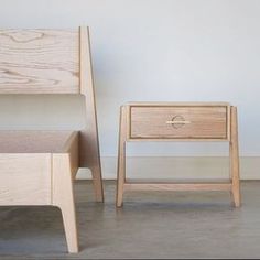 two wooden nightstands sitting next to each other on top of a cement floor in front of a white wall