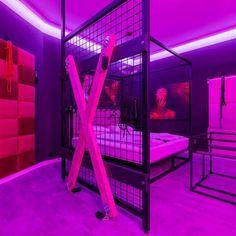 a bedroom with purple lighting and pink walls