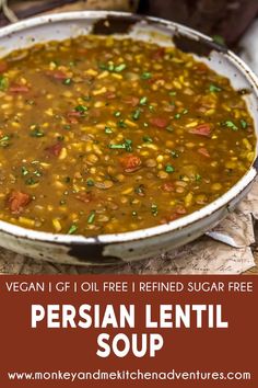 a bowl filled with lentil soup on top of a wooden table