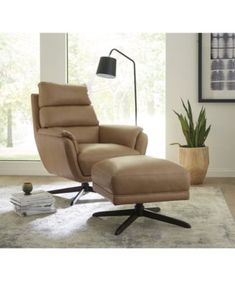 the reclining chair and ottoman is in front of a window with a potted plant