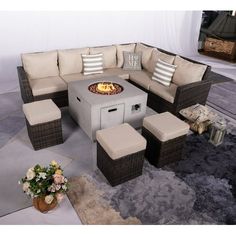 an outdoor fire pit surrounded by wicker furniture