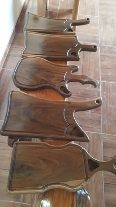 a row of wooden chairs sitting on top of a tiled floor