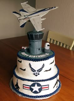 a cake made to look like an air force jet on top of a tower that is sitting on a table