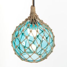 a blue glass ornament hanging from a rope