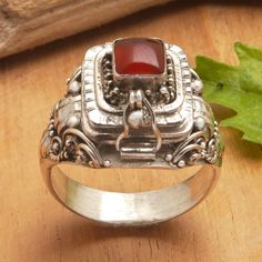 Exuding both style and functionality, this sterling silver locket ring is a true fashion statement as well as the perfect way to store photos and other cherished memories inside its hidden compartment to have them always at hand. Presented by Sukartini, this amazing design is topped by a vibrant carnelian stone beautifully flanked by traditional Balinese motifs, making it a gorgeous and enchanting accessory. Locket Ring, Sterling Silver Locket, Silver Locket, Carnelian Ring, Store Photos, Carnelian Stone, Silver Lockets, Single Stone, Sterling Silver Dangle Earrings