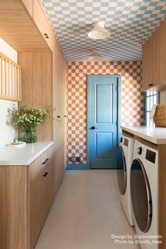 a washer and dryer in a room with checkered wall paper on the walls