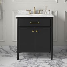 a bathroom vanity with marble top and gold handles