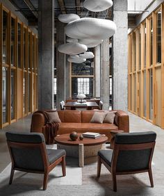 a living room filled with lots of furniture next to tall wooden walls and flooring