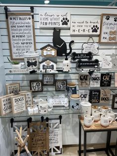 there are many signs and mugs on display in the store window, including one with a dog's name