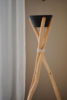 a stool made out of wooden sticks with a black seat