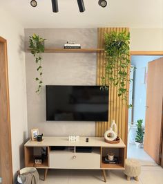 a flat screen tv sitting on top of a wooden entertainment center in a living room