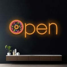 a neon sign that says open with a donut on it in front of a black wall