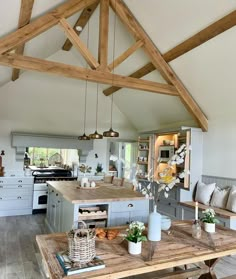 an open kitchen and dining area with wooden beams