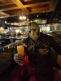 a person wearing a mask holding a drink