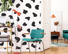 a living room with black and white cow wallpaper