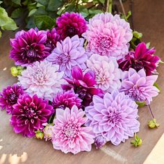 a bunch of purple flowers sitting on top of a wooden table