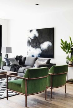 a living room filled with furniture and a painting on the wall