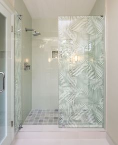 a bathroom with a glass shower door and tiled floor