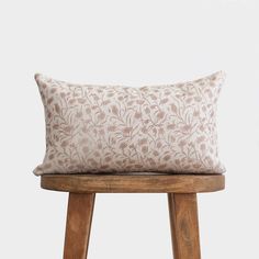 a wooden stool with a pillow on it