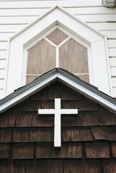 a white cross on top of a wooden building