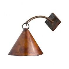 an old fashioned wall light with a metal arm and cone shaped shade on the side