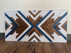 a large wooden wall hanging on top of a hard wood floor