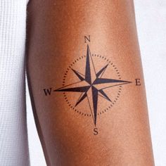 a woman's arm with a compass tattoo on the left side of her body