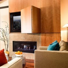 a living room filled with furniture and a flat screen tv mounted to the wall above a fireplace