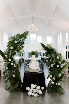 the table is decorated with white flowers and greenery for an elegant touch to the reception