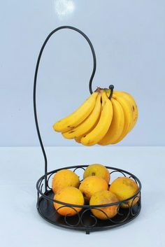 a metal basket filled with bananas and oranges