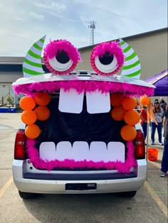 the back end of a car decorated with decorations and eyeballs on it's face