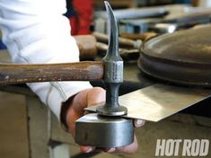 a person holding an object with a hammer in it's hand while working on something