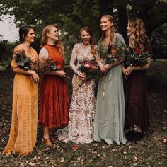 a group of women standing next to each other in front of trees and leaves on the ground