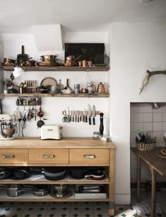 a kitchen with shelves filled with pots and pans