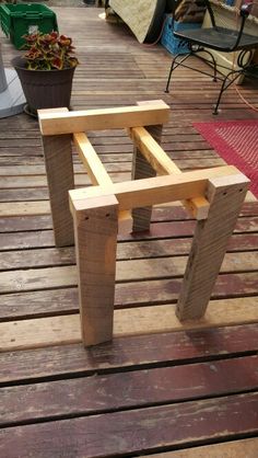 a wooden bench sitting on top of a wooden deck next to a potted plant