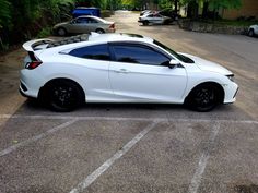 a white sports car parked in a parking lot