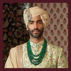 a man wearing a turban and green beads