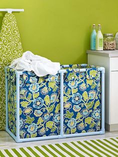 a laundry hamper sitting on top of a floor next to a green and white wall