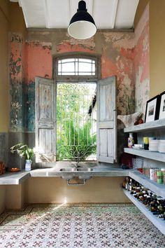 an old bathroom with a sink, window and tiled floor in front of the tub