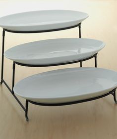 two white plates sitting on top of each other in front of a wooden table with metal legs