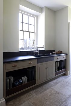 an empty kitchen with two sinks and cabinets in it's center island, next to a window