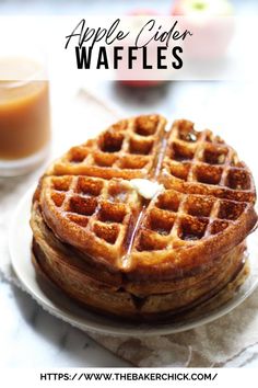 a stack of waffles sitting on top of a white plate next to an orange juice