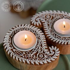 two white candles sitting on top of a green plate